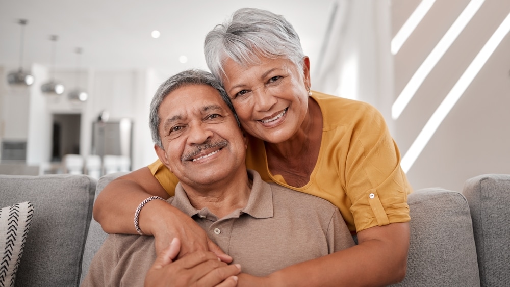 Happy couple embracing on a couch, representing wellness and vitality.